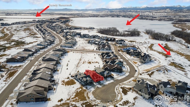 snowy aerial view featuring a residential view and a mountain view