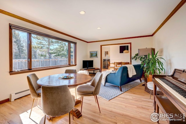 dining space with a baseboard radiator, ornamental molding, and light hardwood / wood-style floors