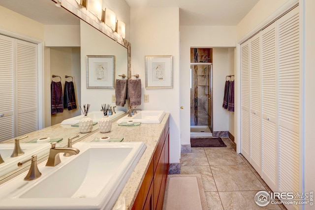 bathroom featuring a shower with door and vanity