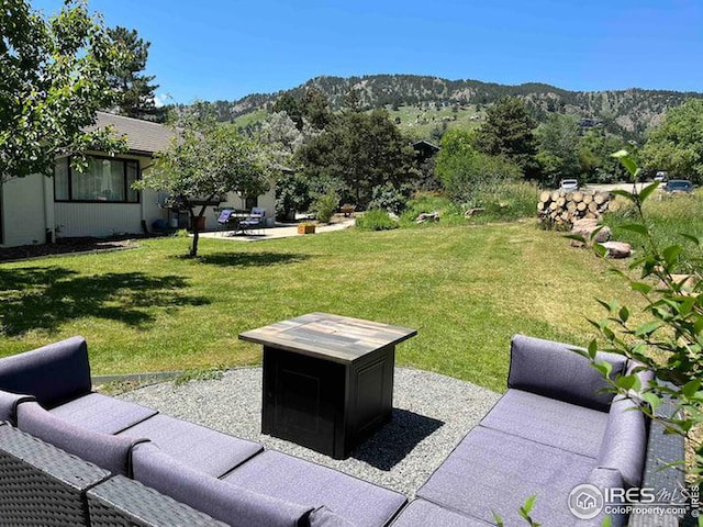 view of yard featuring an outdoor living space, a patio area, and a mountain view