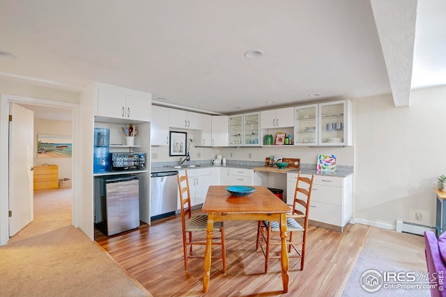 kitchen featuring white cabinetry, stainless steel dishwasher, light hardwood / wood-style floors, and a baseboard heating unit