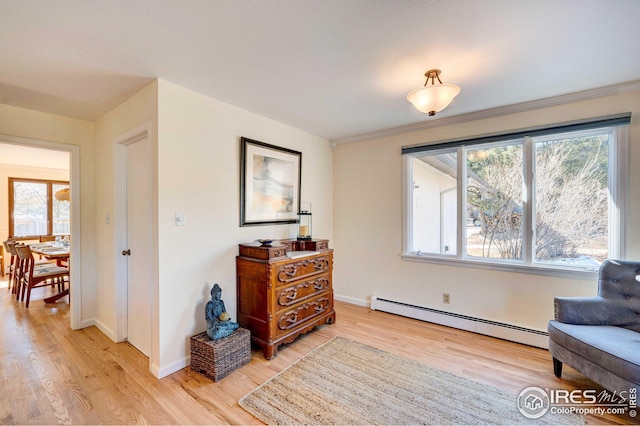 sitting room featuring light hardwood / wood-style flooring and a baseboard heating unit