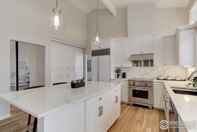 kitchen featuring white cabinetry, high quality appliances, decorative light fixtures, and a center island