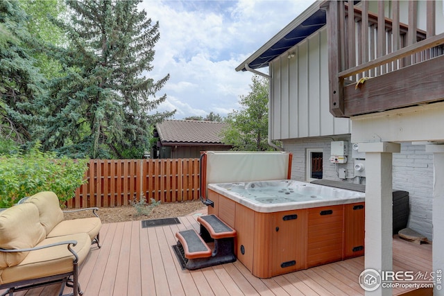 wooden terrace featuring outdoor lounge area and a hot tub