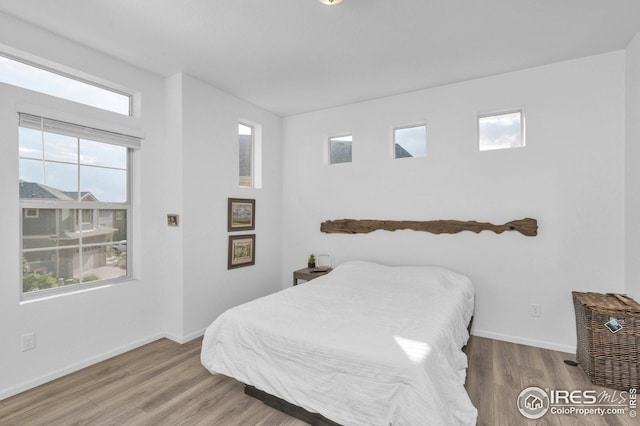 bedroom with wood finished floors and baseboards