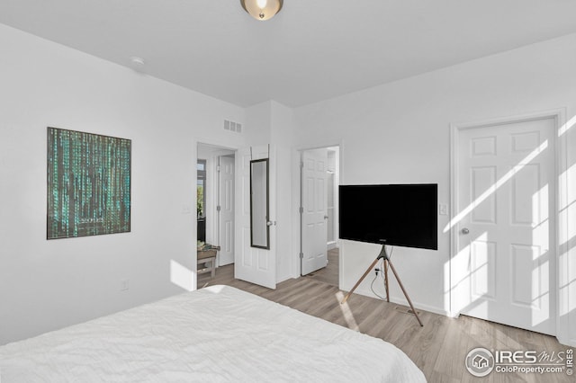 bedroom with visible vents and wood finished floors