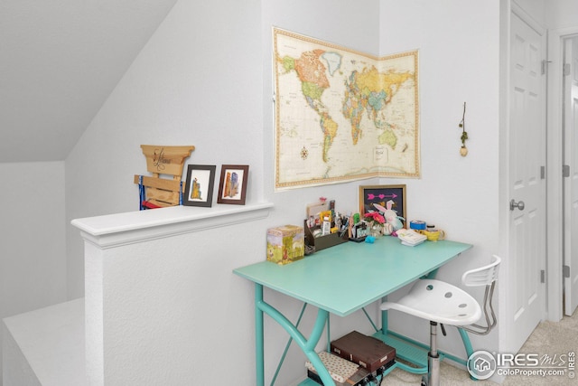 carpeted office featuring vaulted ceiling