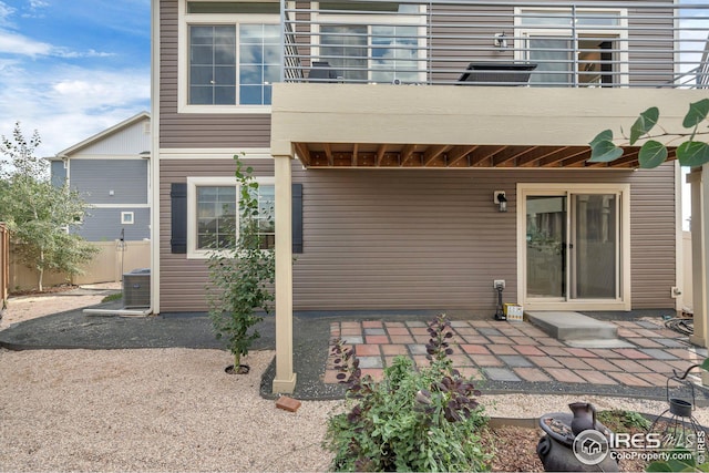 back of property with a patio, a balcony, cooling unit, and fence