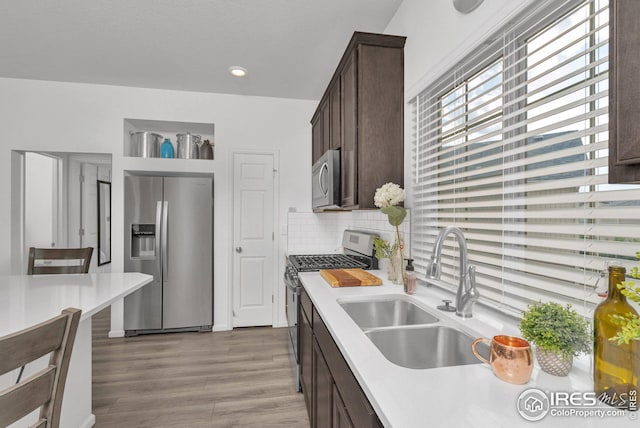 kitchen featuring a sink, appliances with stainless steel finishes, light countertops, and dark brown cabinets