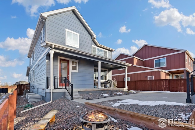 view of front of property featuring covered porch and an outdoor fire pit