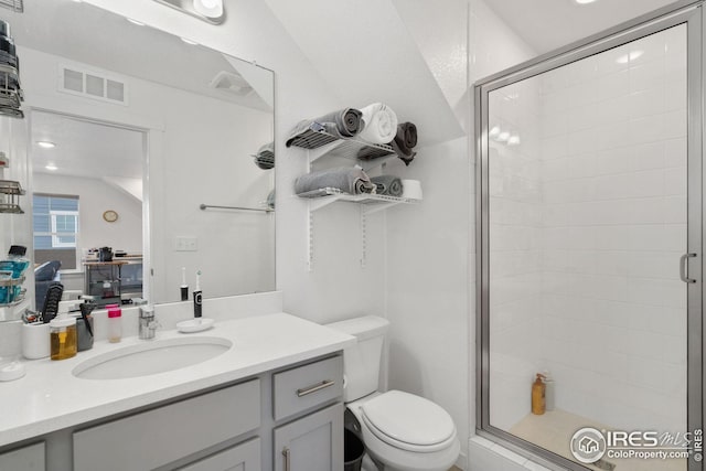 bathroom featuring vanity, toilet, and walk in shower