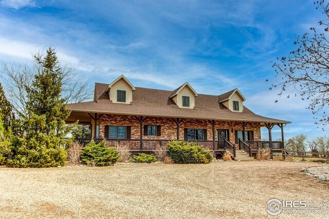 420 E County Road 10, Berthoud, CO 80513 - view of front of home featuring covered porch, brick siding, and a shingled roof