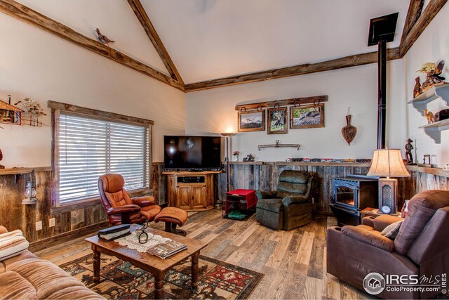 420 E County Road 10, Berthoud, CO 80513 - living room with a wainscoted wall, high vaulted ceiling, wood finished floors, and a wood stove