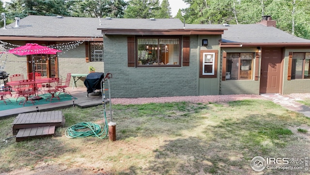 back of house featuring a lawn