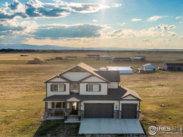 craftsman-style house featuring a porch, a garage, and a rural view