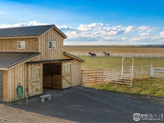 view of horse barn with a rural view