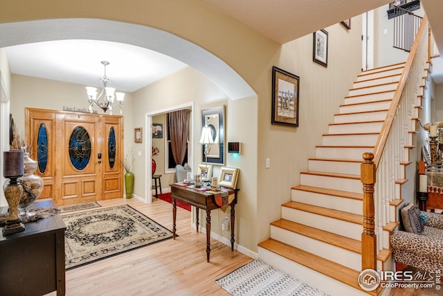 entryway with an inviting chandelier and light wood-type flooring