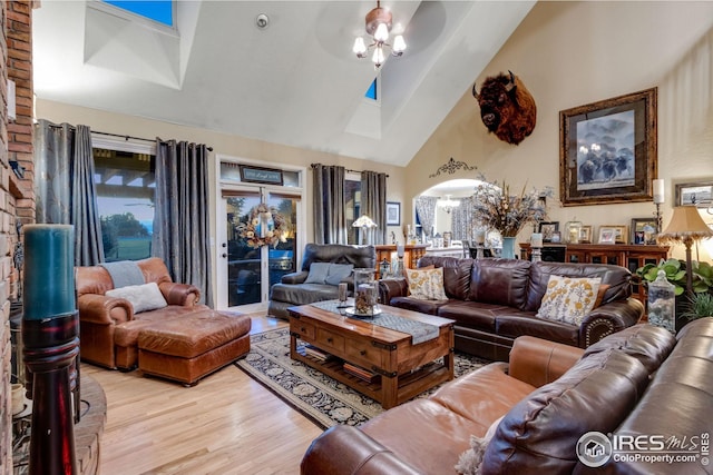 living room with high vaulted ceiling, ceiling fan, and light wood-type flooring