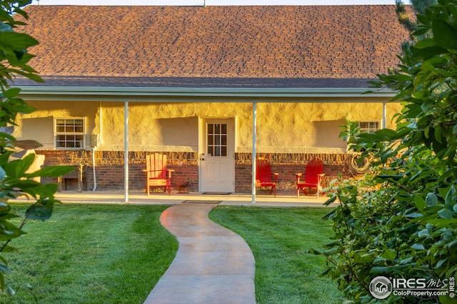 rear view of property featuring a patio and a lawn