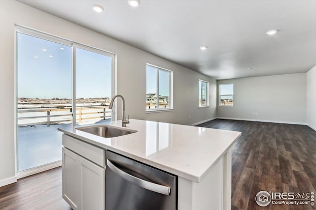 kitchen with sink, dishwasher, white cabinetry, a kitchen island with sink, and light stone counters