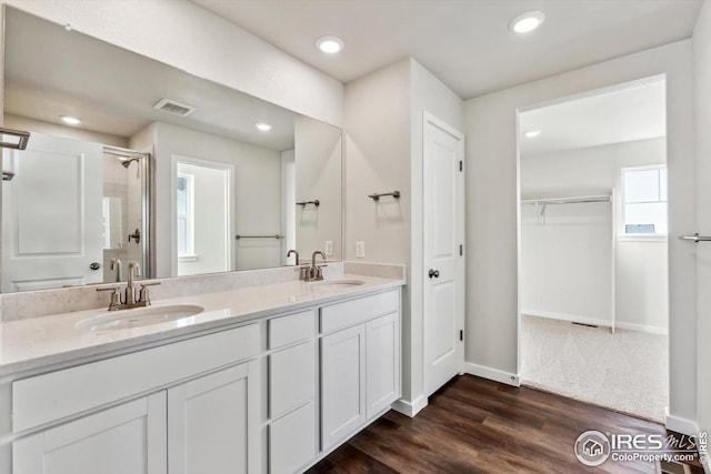 bathroom with hardwood / wood-style flooring, vanity, and a shower with shower door