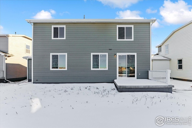 view of snow covered rear of property