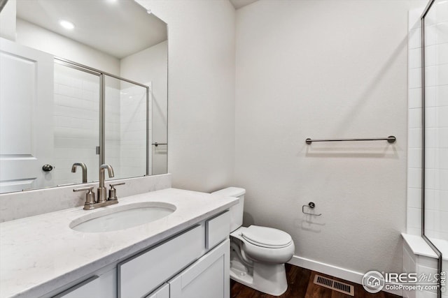 bathroom featuring an enclosed shower, vanity, hardwood / wood-style flooring, and toilet