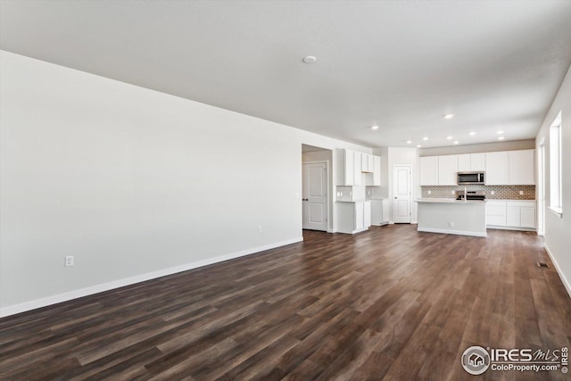 unfurnished living room featuring dark wood-type flooring