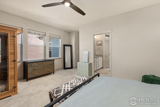 bedroom featuring ceiling fan, ensuite bath, and light carpet