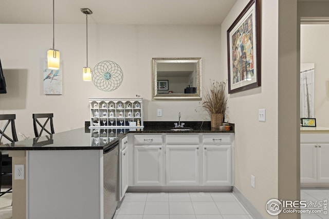 kitchen with sink, dark stone countertops, hanging light fixtures, white cabinets, and kitchen peninsula