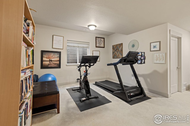 workout room with light carpet and a textured ceiling