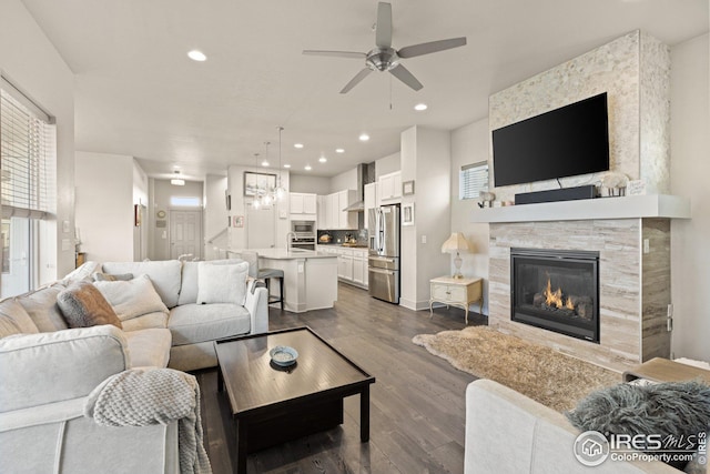 living room featuring dark wood-type flooring, ceiling fan, and sink