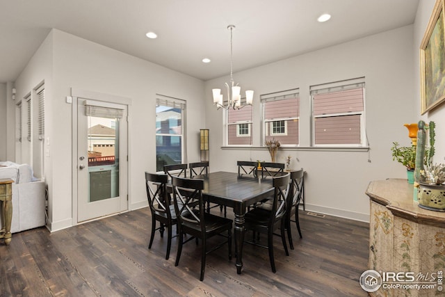 dining area featuring dark wood-type flooring and a notable chandelier