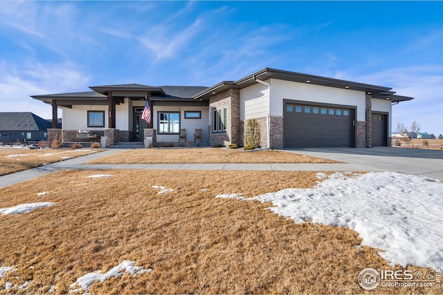 prairie-style house featuring covered porch, an attached garage, and concrete driveway