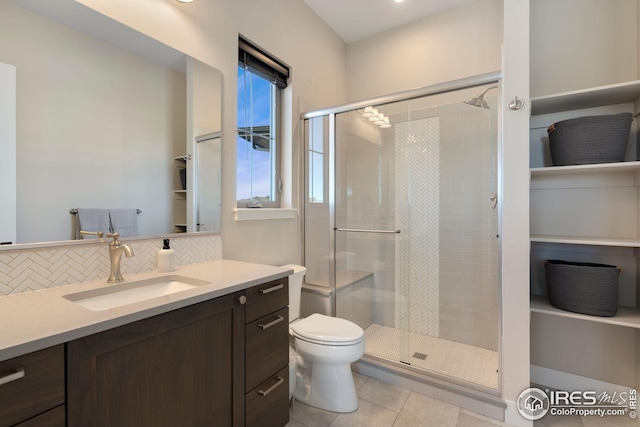 full bath with vanity, tile patterned flooring, toilet, a shower stall, and tasteful backsplash