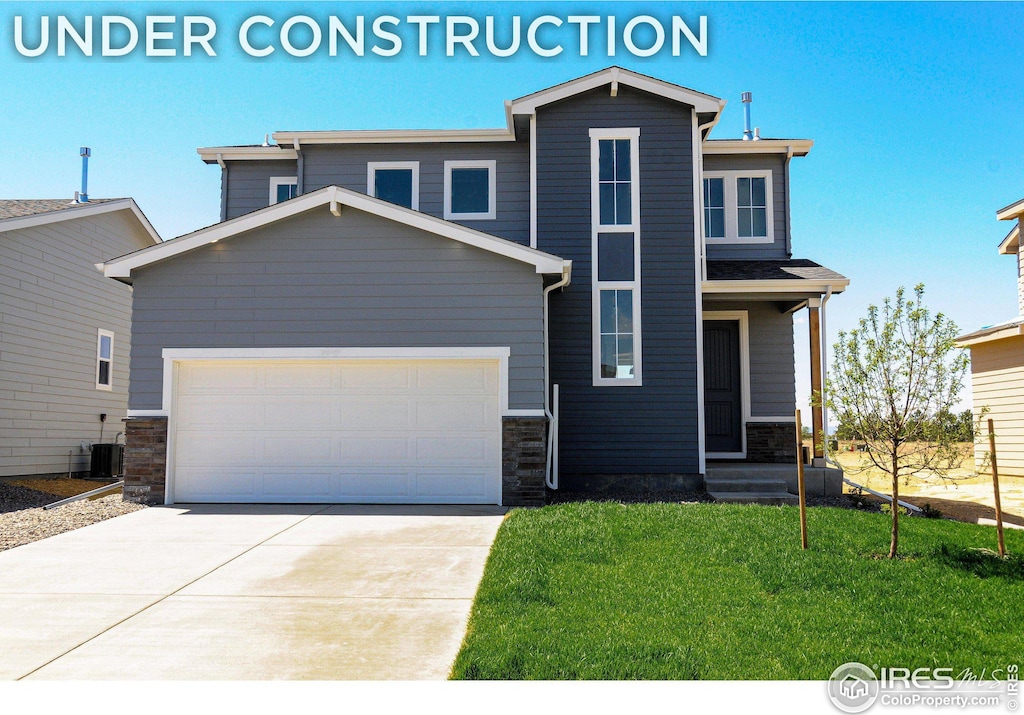 view of front of house with cooling unit, a garage, and a front yard