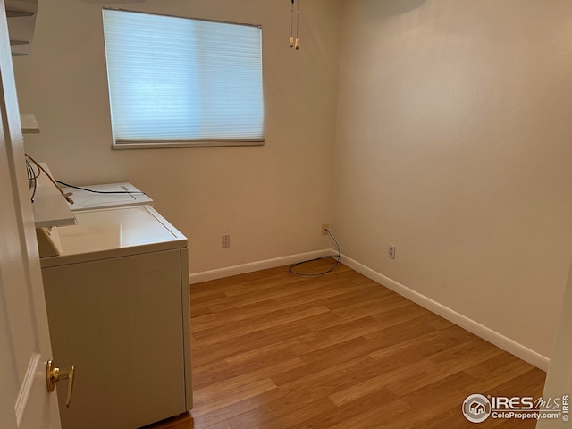 clothes washing area with separate washer and dryer and light hardwood / wood-style flooring