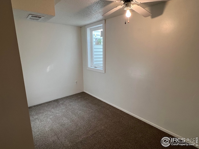 carpeted empty room with ceiling fan and a textured ceiling