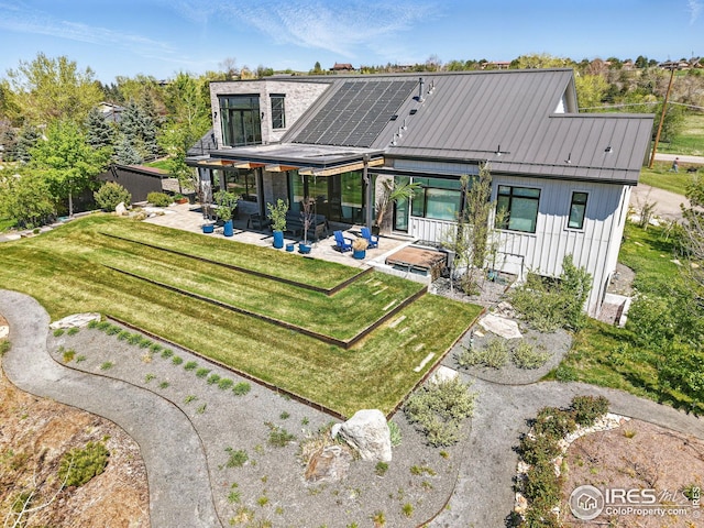635 Paragon Dr, Boulder, CO 80303 - rear view of house featuring a patio, board and batten siding, a standing seam roof, a fenced backyard, and a metal roof
