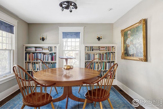 dining space featuring baseboards and wood finished floors