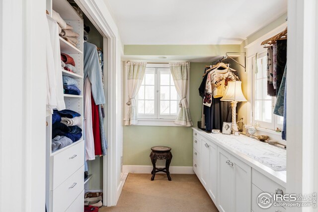 mudroom featuring baseboards and light colored carpet
