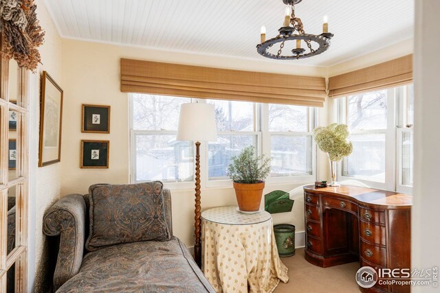 sitting room with carpet flooring, a notable chandelier, and ornamental molding