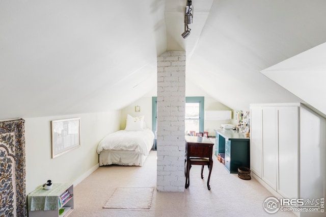 bedroom with light colored carpet and lofted ceiling