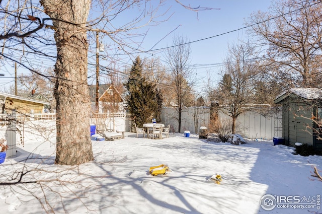 yard covered in snow with a shed