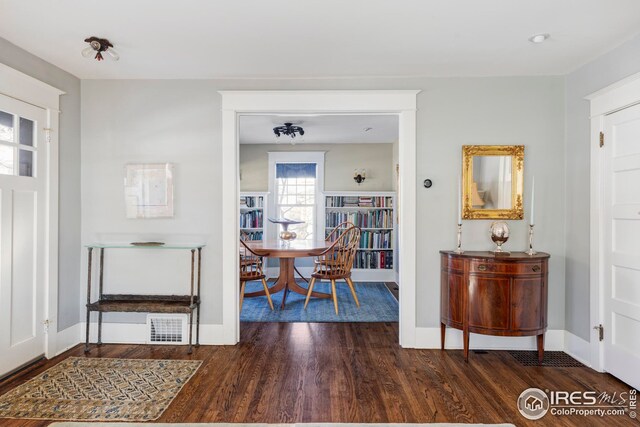 interior space with baseboards, wood finished floors, and visible vents