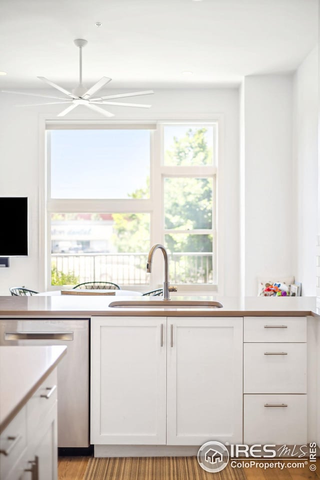 kitchen with dishwasher, sink, and white cabinets