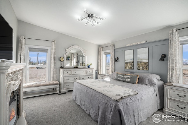 carpeted bedroom with lofted ceiling and multiple windows