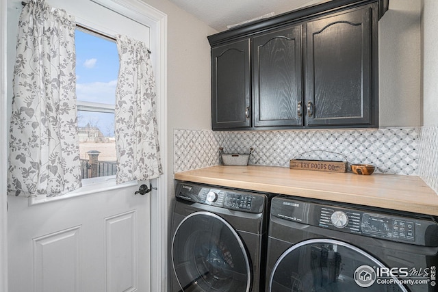 washroom featuring cabinets and washing machine and dryer