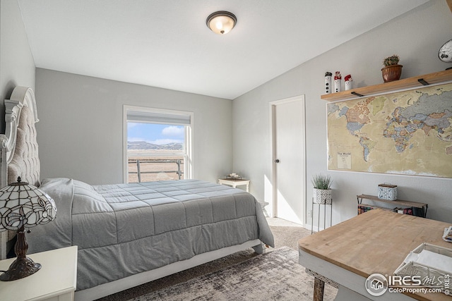 bedroom featuring vaulted ceiling and carpet flooring