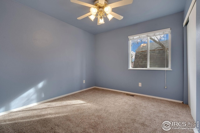 carpeted spare room featuring ceiling fan